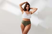 Donna in reggiseno appoggiata al telaio della porta
