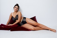 Donna in reggiseno appoggiata al telaio della porta