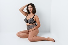 Donna in reggiseno appoggiata al telaio della porta